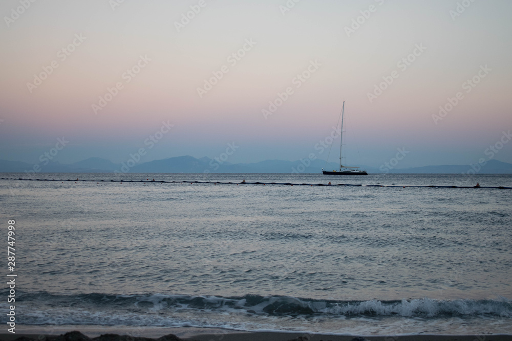 Sailboat sailing on the horizon in the light of the sunset Sailboat sailing on the horizon in the light of the sunset