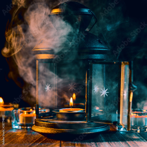 Halloween holiday concept design of pumpkin, candle, spooky decorations with green tone smoke around on a dark wooden table, close up shot. © RomixImage