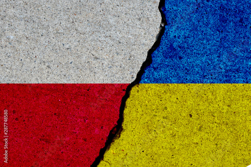 poland and ukraine flags painted over cracked concrete wall