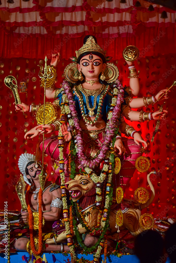 Fototapeta premium Idol of Goddess Devi Durga at a decorated puja pandal in Kolkata, West Bengal, India. Durga Puja is a famous and major religious festival of Hinduism that is celebrated throughout the world.