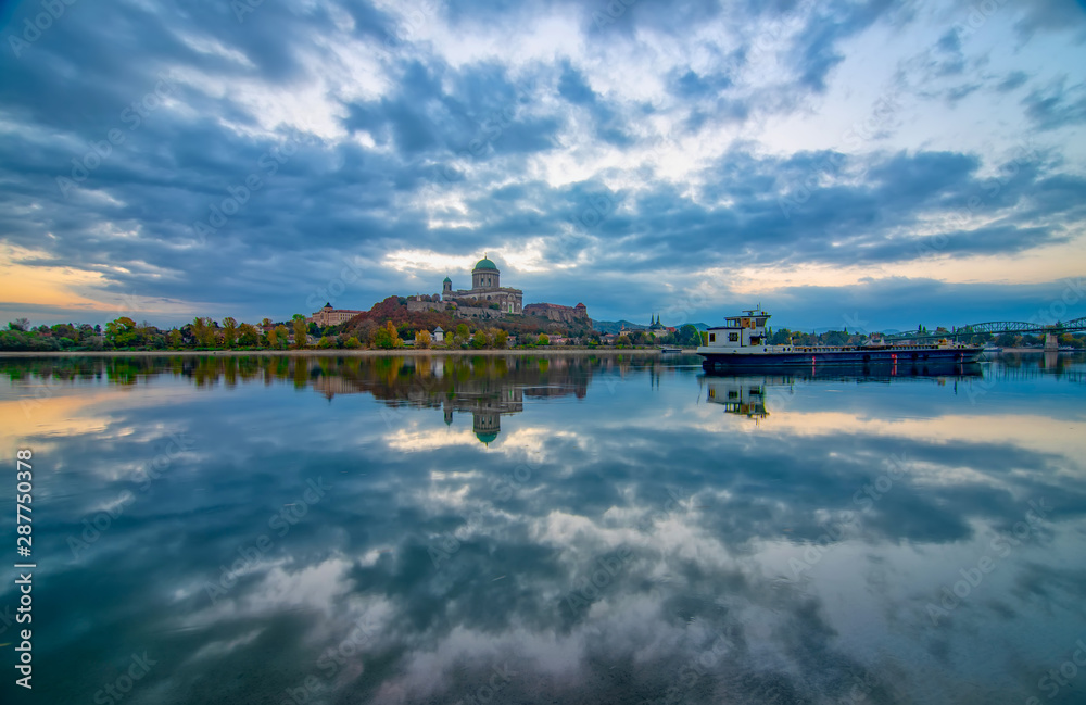 Amazing sunrise view over Danube river, beautiful reflections of morning clouds mirrored in water, Esztergom, Hungary