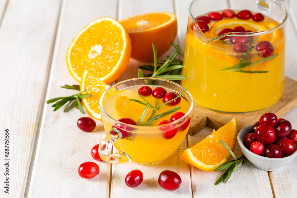 Autumn crunberry, rosemary and orange steaming tea on rustic background Autumn crunberry, rosemary and orange steaming tea on rustic background