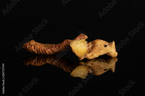 Group of two pieces of orange rind with roseship of lingonberry strawberry fruit tea macro isolated on black glass photo