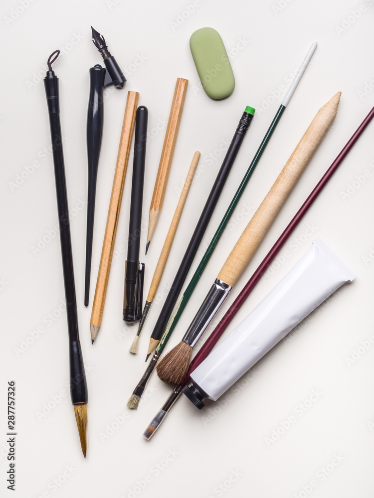 Brushes, pens and pencils on a white background. Flat lay Brushes, pens and pencils on a white background. Flat lay