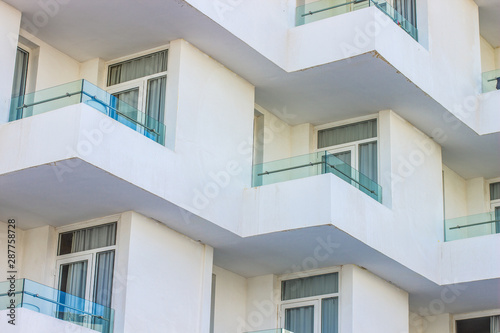 white building exterior facade with balcony and windows 