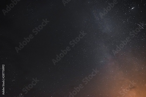 Milky way in the night sky through the clouds on a summer night