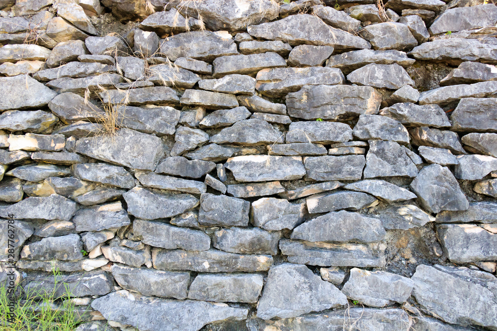 wall of old stones overgrown with grass, close-up wall of old stones overgrown with grass, close-up