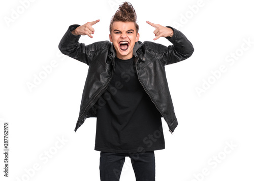 Crazy teen boy with spooking make-up making Rock Gesture, isolated on white background. Teenager in style of punk goth dressed in black screaming and shouting and doing heavy metal rock sign.