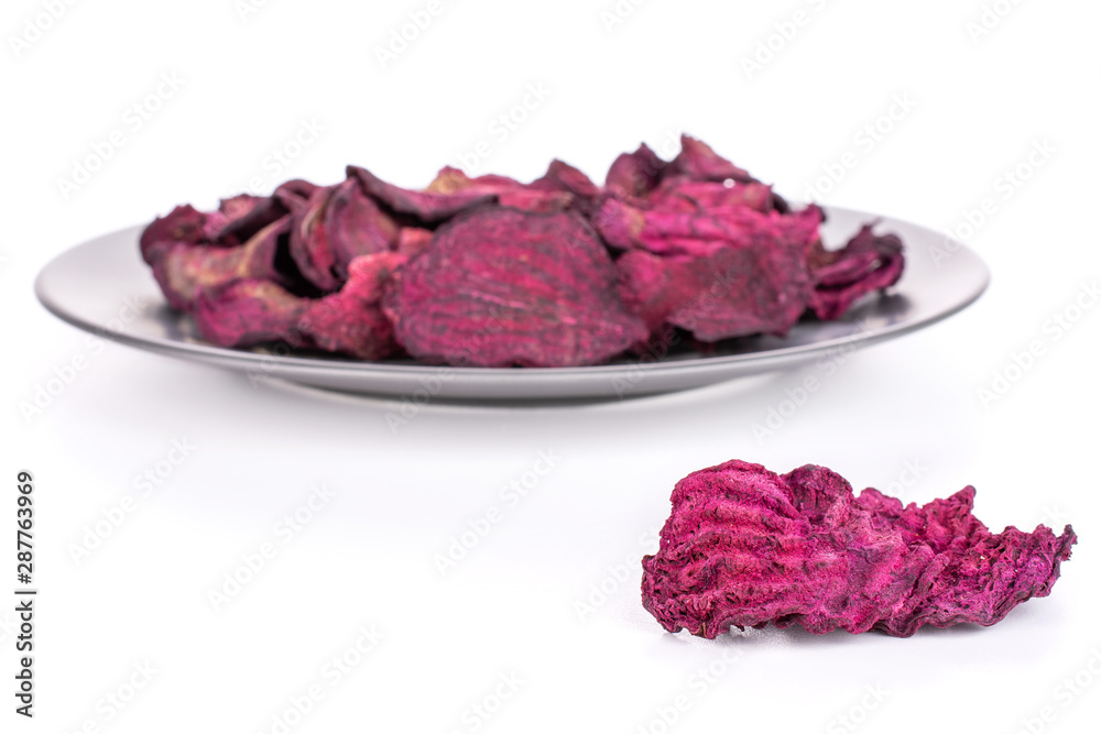 Lot of slices of dried red beetroot on gray ceramic plate isolated on white background Lot of slices of dried red beetroot on gray ceramic plate isolated on white background