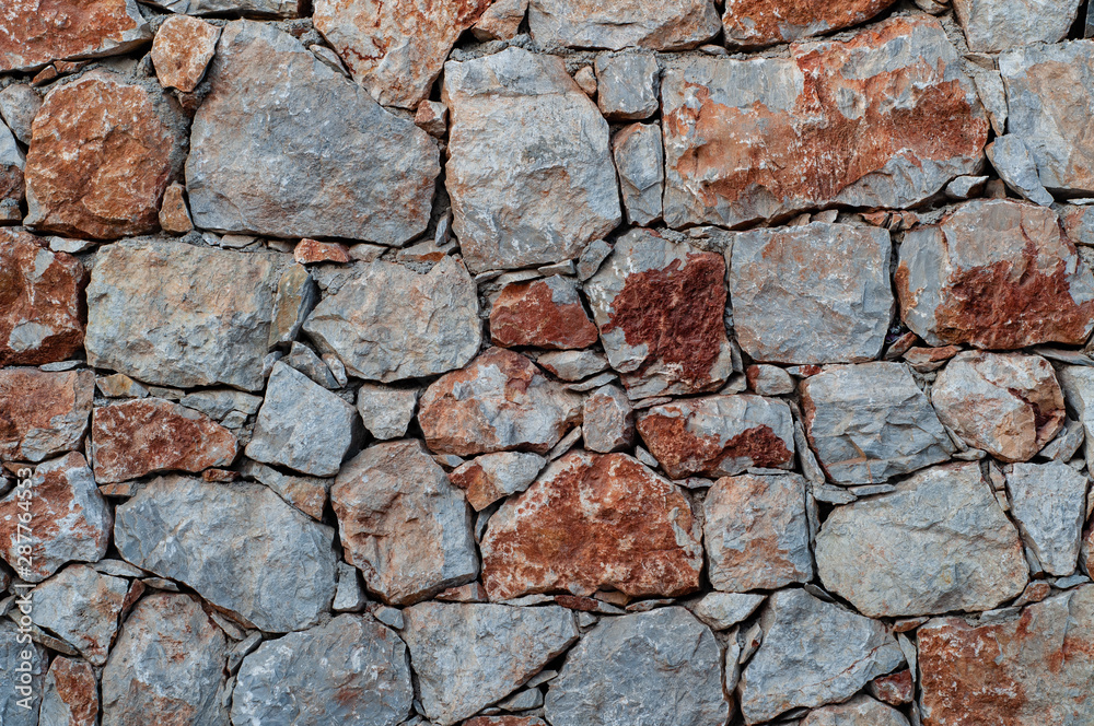 Modern wall of large unprocessed pieces of rock, stones. Background stone wall. Modern wall of large unprocessed pieces of rock, stones. Background stone wall.