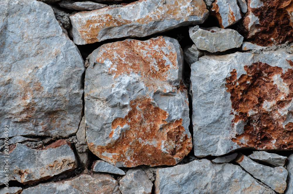 Modern wall of large unprocessed pieces of rock, stones. Background stone wall. Modern wall of large unprocessed pieces of rock, stones. Background stone wall.