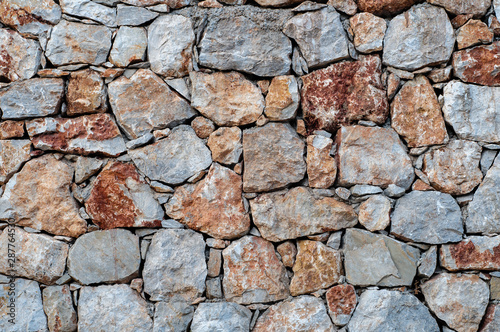 Modern wall of large unprocessed pieces of rock  stones. Background stone wall.