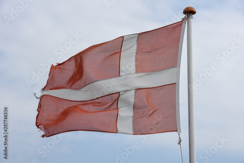 Denish flag waving against blue sky photo