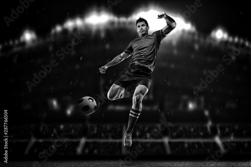 Soccer player in action on a dark background © romanolebedev