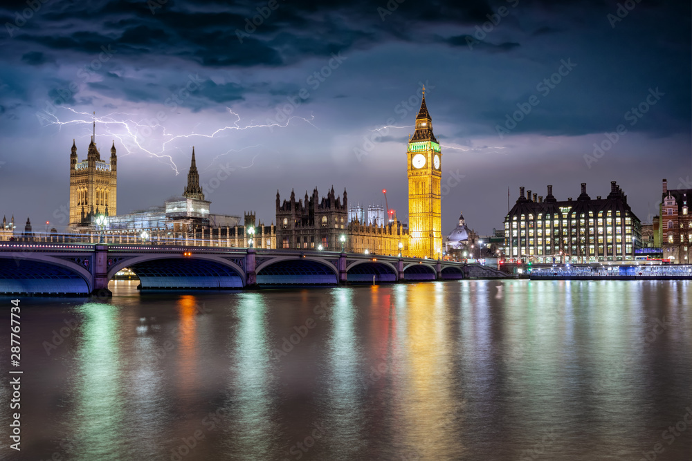 Blick auf den beleuchteten Westminster Palast mit Big Ben Turm an der Themse bei Gewitter und Sturm in London, Großbritannien