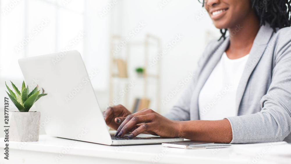 Unrecognizable Afro Businesswoman Typing On Laptop In Modern Office Unrecognizable Afro Businesswoman Typing On Laptop In Modern Office