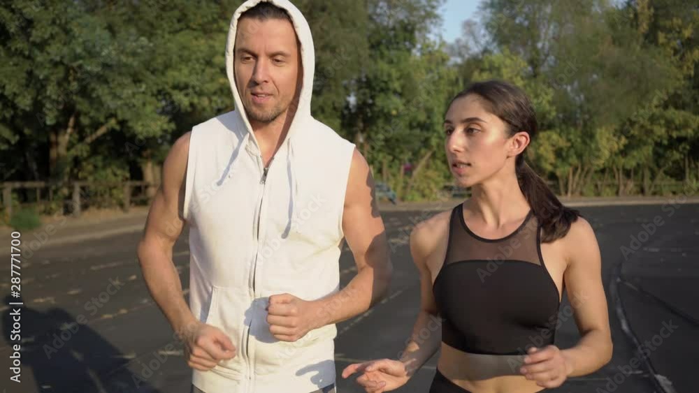 guy and girl run around the stadium on a hot summer day guy and girl run around the stadium on a hot summer day