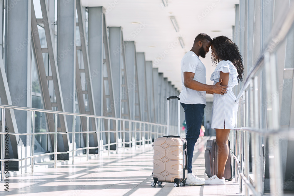 African couple hugging tight after long separation in airport African couple hugging tight after long separation in airport