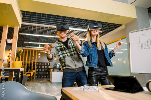 business people, young hipster couple at modern office indoors have fun wearing virtual reality headset