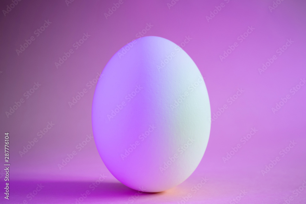 Close-up egg in neon trend purple color. Protein, a stylish simple meal. Minimalism, place for text, design. Close-up egg in neon trend purple color. Protein, a stylish simple meal. Minimalism, place for text, design.