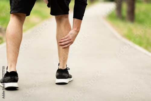 Male runner is suffering from calf pain on jogging