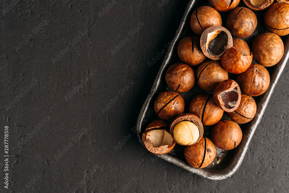 Obraz premium Macadamia nuts on a dark background
