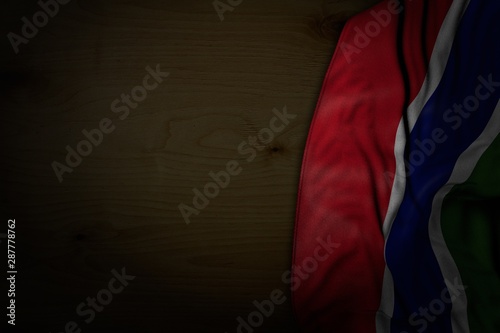 nice any holiday flag 3d illustration. - dark image of Gambia flag with big folds on dark wood with empty space for text