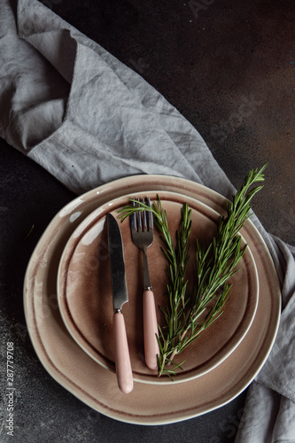 Table setting with ceraic plates and rosemary photo