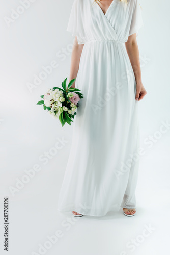 cropped view of bride in wedding dress holding bouquet