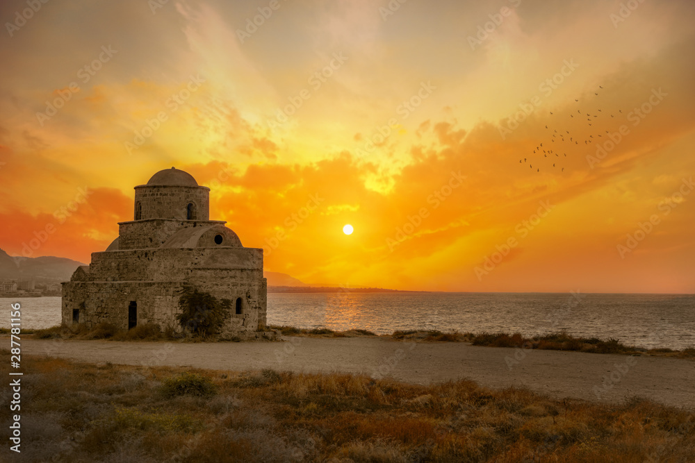 Old stone historic building on the sea coast at sunset in Northern Cyprus.