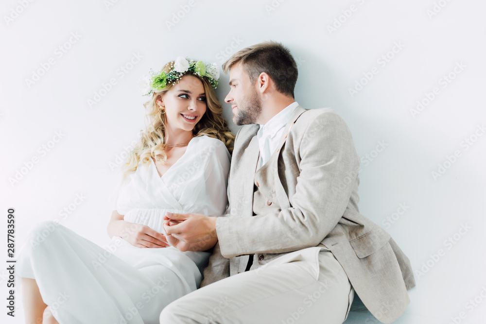 attractive bride and handsome bridegroom smiling and looking at each other