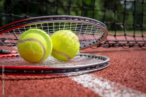 Two tennis balls resting on top of tennis racquet © NetPix