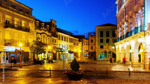 Aveiro, Portugal. View of city center at night with illuminated buildings and car trails. Time-lapse at night with dark blue sky