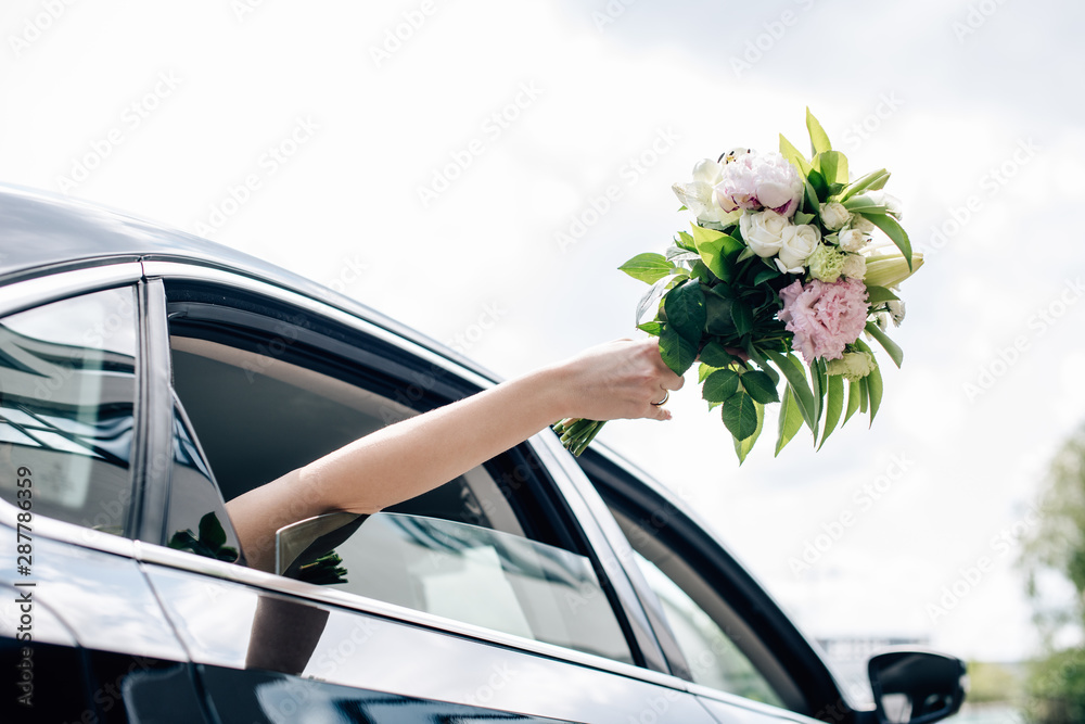cropped view of young adult bride holding holding bouquet - obrazy, fototapety, plakaty 
