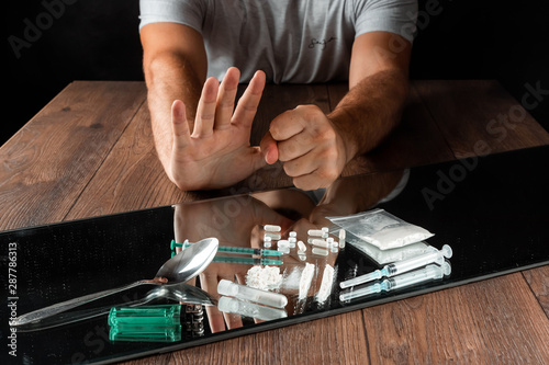 Photography A man with a stop gesture refuses drugs, the fight against drug addiction