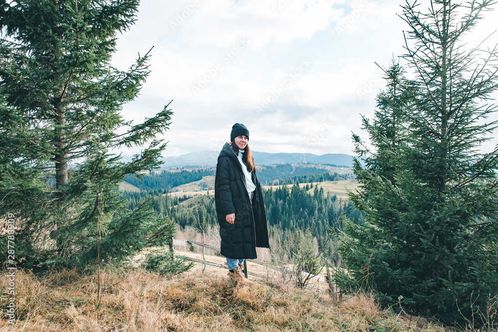 young pretty woman standing at cliff with beautiful mountains view young pretty woman standing at cliff with beautiful mountains view