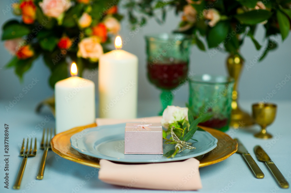 turquoise-colored table with gold plates and cutlery