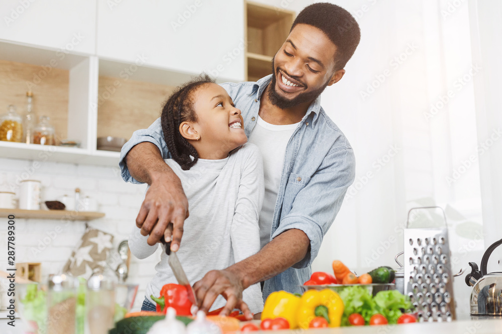 Dad teaching little girl how to cut vegetables Dad teaching little girl how to cut vegetables