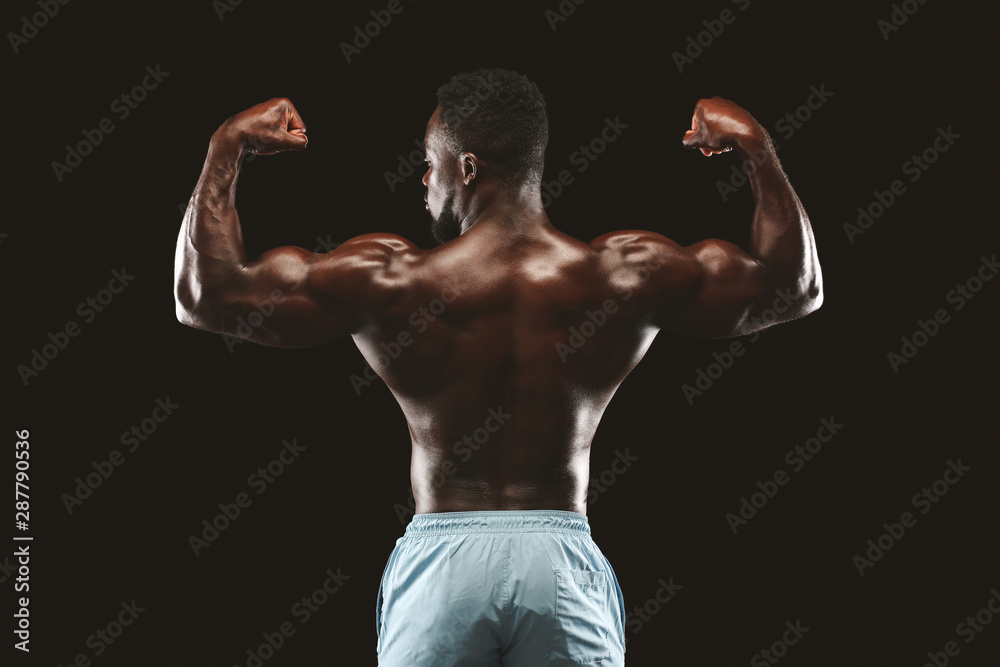 Muscular black fitness model posing after exercises