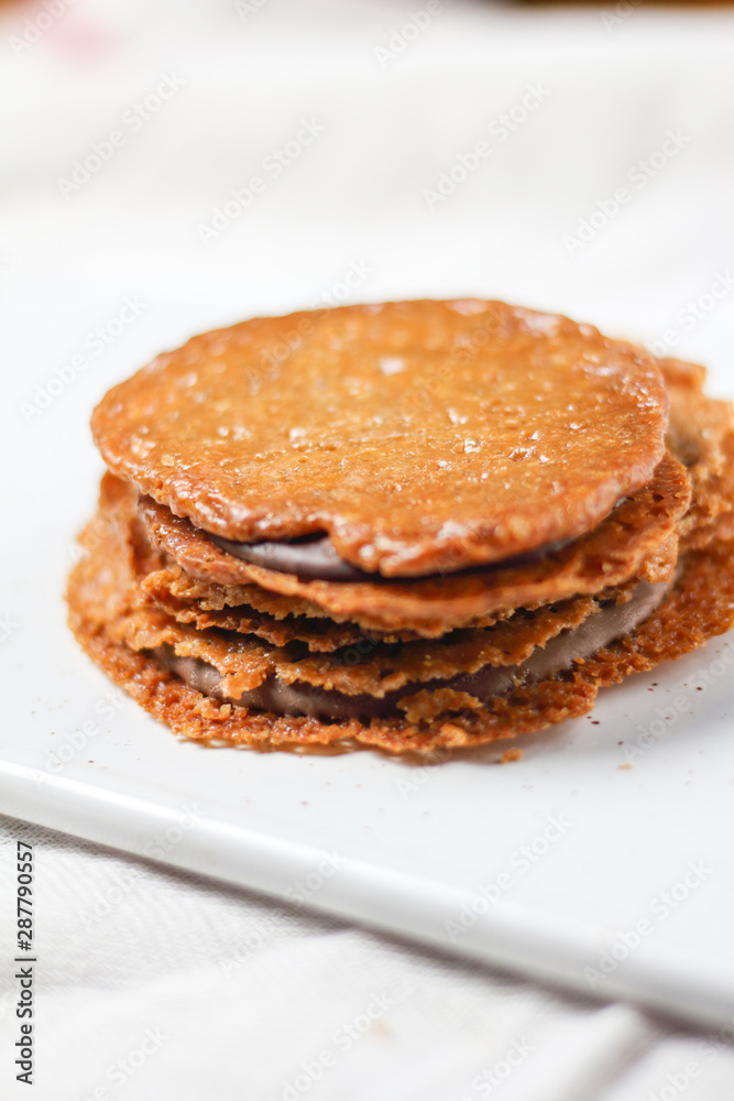 chocolate filled almond brown cookies sandwiches biscuits on white plate. Homemade delicious dessert chocolate filled almond brown cookies sandwiches biscuits on white plate. Homemade delicious dessert