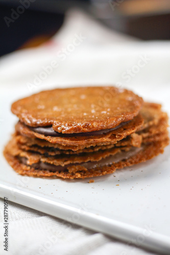chocolate filled almond brown cookies sandwiches biscuits on white plate. Homemade delicious dessert