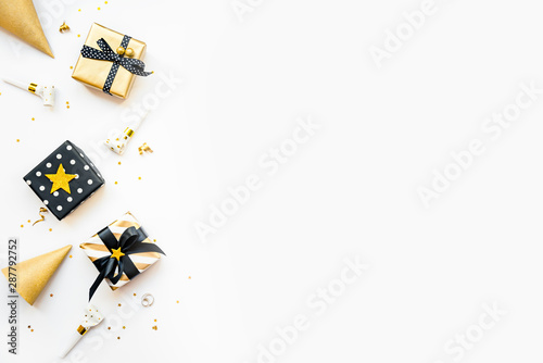 Top view of gift boxes and party accessories in various black, white and golden designs. Flat lay, copy space. A concept of Christmas, New Year, birthday celebration event.