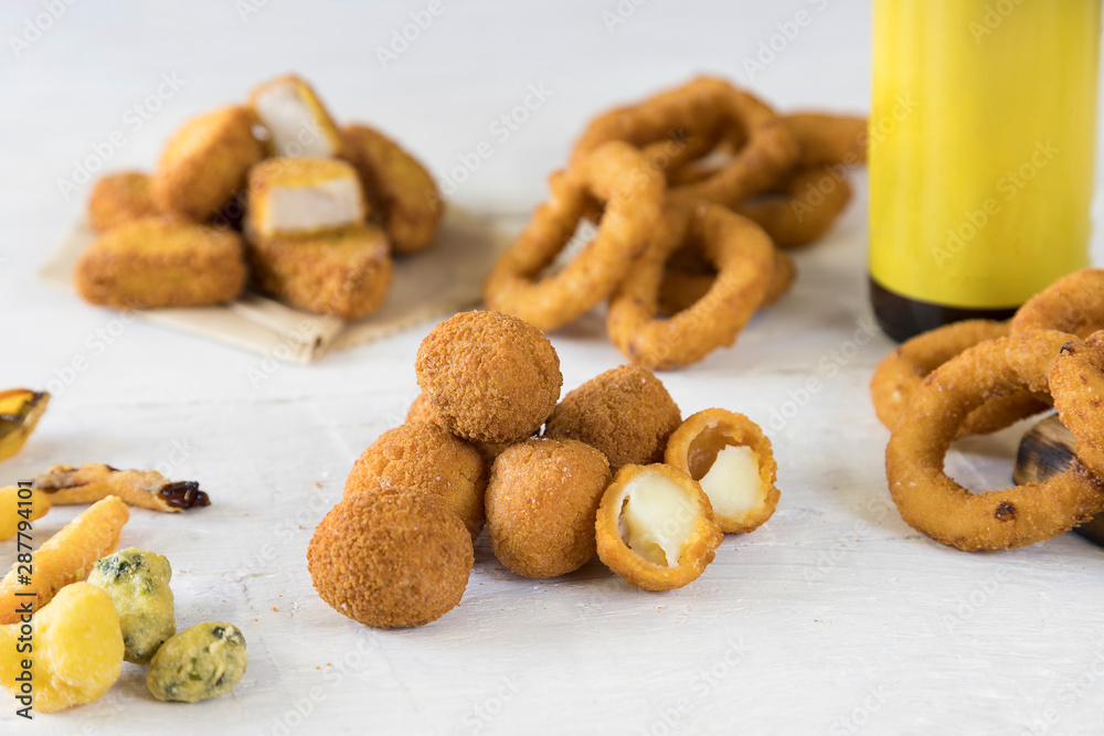 Fast food products onion rings, french fries, chicken nuggets, olive