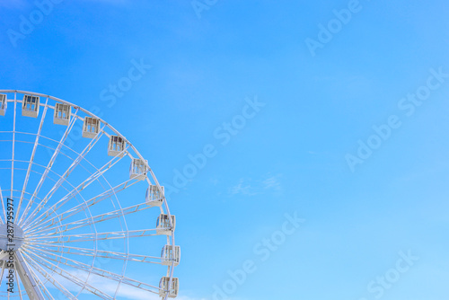 Ferris wheel in an amusement park at the summer. Copy space for text. Blue sky