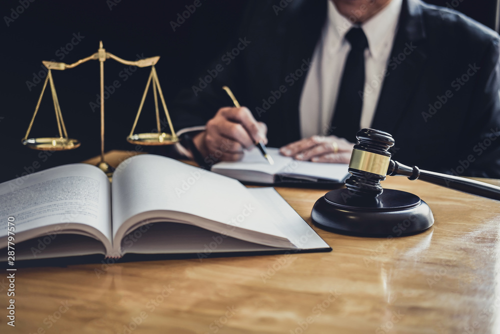 Professional Male lawyer or judge working with contract papers, documents and gavel and Scales of justice on table in courtroom, Law and Legal services concept Professional Male lawyer or judge working with contract papers, documents and gavel and Scales of justice on table in courtroom, Law and Legal services concept