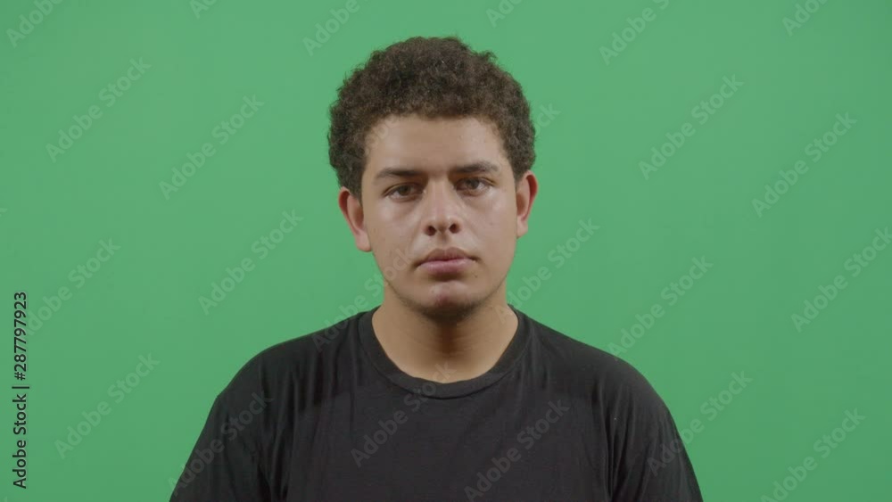 Young Boy Looking At Camera With Suspicion Like Something Strange Is Happening Behind It Young Boy Looking At Camera With Suspicion Like Something Strange Is Happening Behind It