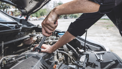 Services car engine machine concept, Automobile mechanic repairman hands repairing a car engine automotive workshop with a wrench, car service and maintenance