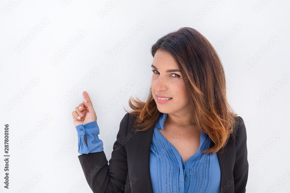 brunette woman with executive jacket, pointing at the white wall, isolated on white background. CopySpace on the left. brunette woman with executive jacket, pointing at the white wall, isolated on white background. CopySpace on the left.