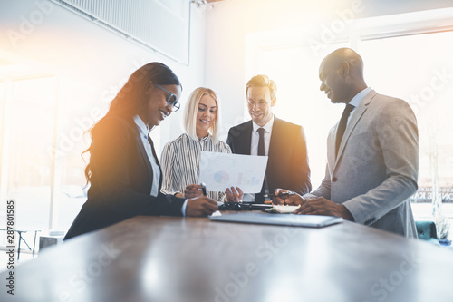 Diverse businesspeople smiling while working together around an photo