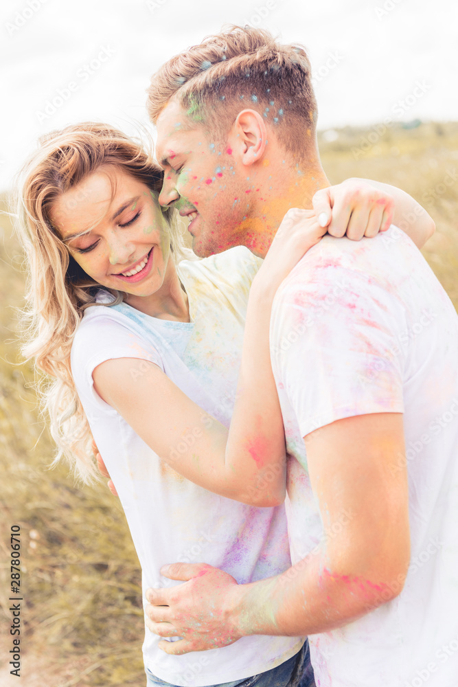 attractive woman and handsome man smiling and kissing outside